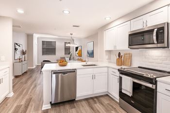 A modern kitchen with white cabinets and stainless steel appliances